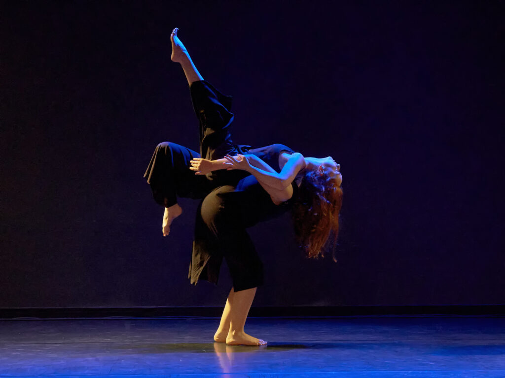 Zwei Tänzerinnen auf einer dunklen Bühne