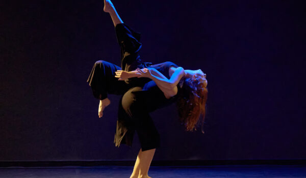 Zwei Tänzerinnen auf einer dunklen Bühne